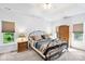 Bedroom featuring a wrought iron bed frame, tray ceiling, and natural light from windows at 5238 Downing Creek Dr, Charlotte, NC 28269