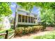 View of back of home with chimney and screened in porch, complemented by manicured bushes and a wooden fence at 5238 Downing Creek Dr, Charlotte, NC 28269