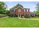 Charming brick home with manicured lawn, dark shutters, and inviting front entrance at 5302 Fairgrove Ln, Harrisburg, NC 28075