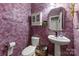 Chic powder room with stylish fixtures, unique textured walls, and a pedestal sink at 5302 Fairgrove Ln, Harrisburg, NC 28075