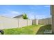 Fenced backyard with lawn, plants, and the home's siding visible under a bright sky at 5337 Orchid Bloom Dr, Indian Land, SC 29707