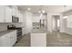 Stylish kitchen with stainless appliances, white cabinets, and granite island, perfect for cooking at 5337 Orchid Bloom Dr, Indian Land, SC 29707