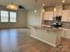 Open-concept kitchen and living area with a center island, white cabinets, and stainless steel appliances at 5337 Orchid Bloom Dr, Indian Land, SC 29707