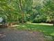 Lush backyard offering a serene view, partially shaded by mature trees and complemented by a charming wooden fence at 5828 Wilora Lake Rd, Charlotte, NC 28212