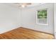Bright bedroom features hardwood floors, natural light, and a window with green outdoor views at 5828 Wilora Lake Rd, Charlotte, NC 28212