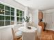 A bright breakfast nook features a round table and a big window with a view of the greenery outside at 5828 Wilora Lake Rd, Charlotte, NC 28212