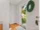 Bright entryway featuring hardwood floors, white trim, and a view to the lush outdoor landscape and mature trees at 5828 Wilora Lake Rd, Charlotte, NC 28212
