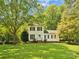 Charming two-story home with white siding, black shutters, and a well-manicured lawn surrounded by mature trees at 5828 Wilora Lake Rd, Charlotte, NC 28212