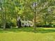 Attractive two-story house surrounded by mature trees and a spacious, well-maintained front lawn for a peaceful setting at 5828 Wilora Lake Rd, Charlotte, NC 28212