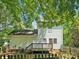 Back exterior of home features a fenced yard, a deck, and mature shade trees at 5828 Wilora Lake Rd, Charlotte, NC 28212