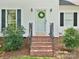 Inviting front entrance with a wreath on the door, brick steps, and trimmed bushes on both sides at 5828 Wilora Lake Rd, Charlotte, NC 28212