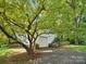 Attached garage with white door and siding, complemented by a lush green lawn and mature tree with ample shade at 5828 Wilora Lake Rd, Charlotte, NC 28212