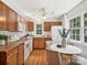 Well-equipped kitchen with wooden cabinets, white appliances, and a breakfast nook near a bright window at 5828 Wilora Lake Rd, Charlotte, NC 28212