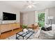 Cozy living room featuring hardwood floors, a modern TV console, and a large window overlooking the yard at 5828 Wilora Lake Rd, Charlotte, NC 28212