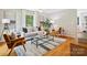Cozy living room with hardwood floors, ceiling fan, large window, and stylish furnishings, creating a comfortable space at 5828 Wilora Lake Rd, Charlotte, NC 28212