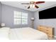 Bedroom with a ceiling fan, large window, TV, and dresser providing a comfortable and functional space at 5980 Cougar Ln, Charlotte, NC 28269