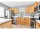 Well-lit kitchen featuring wood cabinets, stainless steel appliances, and a window above the sink at 5980 Cougar Ln, Charlotte, NC 28269
