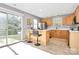 Bright kitchen with bar seating, wood cabinets, stainless steel appliances, and sliding glass door to patio at 5980 Cougar Ln, Charlotte, NC 28269