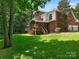 View of backyard, screened porch, and multi-story brick house in a lush setting at 610 Hampshire Hill Rd, Matthews, NC 28105