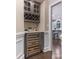 Gray bar area features a wine refrigerator, wine rack, countertop, and access to the kitchen at 610 Hampshire Hill Rd, Matthews, NC 28105