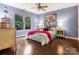 Bedroom featuring hardwood floors, a large window, a ceiling fan, and stylish decor at 610 Hampshire Hill Rd, Matthews, NC 28105