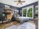 Bedroom featuring wood floors, a ceiling fan, a large window and a full-sized bed with a gray comforter at 610 Hampshire Hill Rd, Matthews, NC 28105