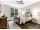Cozy bedroom with dark wood floors, large window, ceiling fan, and comfortable decor at 610 Hampshire Hill Rd, Matthews, NC 28105