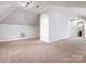 Large bonus room with neutral carpet, sloped ceilings, and good natural light at 610 Hampshire Hill Rd, Matthews, NC 28105