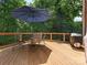 Outdoor deck area featuring a table with an umbrella, chairs, and a grill at 610 Hampshire Hill Rd, Matthews, NC 28105