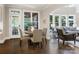Dining area with dark wood floors, round table, four chairs, and access to porch and living room at 610 Hampshire Hill Rd, Matthews, NC 28105