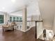 Bright, open hallway with hardwood floors, white railings, and large windows offering natural light at 610 Hampshire Hill Rd, Matthews, NC 28105
