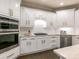 Gourmet kitchen featuring white cabinets, stainless steel appliances, tile backsplash and dark wood floors at 610 Hampshire Hill Rd, Matthews, NC 28105