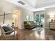 Cozy living room features hardwood floors, a comfortable green sofa, and ample natural light from a large window at 610 Hampshire Hill Rd, Matthews, NC 28105