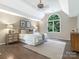 Bright bedroom with hardwood floors, a large arched window overlooking lush greenery, and neutral decor at 610 Hampshire Hill Rd, Matthews, NC 28105