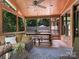 Covered porch featuring wood floors, seating, and access to an outdoor backyard space at 610 Hampshire Hill Rd, Matthews, NC 28105
