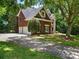 Side view of the home featuring a three-car garage and lush greenery at 610 Hampshire Hill Rd, Matthews, NC 28105