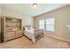 A cozy bedroom featuring carpeted floors, a wooden single bed, and large window letting in plenty of natural light at 6417 Loyola Ct, Mint Hill, NC 28227