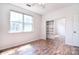 Bedroom with wood-look flooring, a window, and closet with mirrored sliding doors at 8655 Meadowmont View Dr, Charlotte, NC 28269
