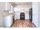 Modern kitchen featuring white cabinetry, sleek black appliances, wood floors, and abundant natural light at 8655 Meadowmont View Dr, Charlotte, NC 28269