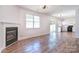 Bright and airy living room with wood-look floors, featuring a fireplace, and an open layout connected to the kitchen at 8655 Meadowmont View Dr, Charlotte, NC 28269