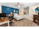 Comfortable bedroom featuring a desk, ceiling fan, and fireplace with white-painted bed and display cabinet at 10007 Hillspring Dr, Huntersville, NC 28078