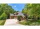 Beautiful two-story brick home with a long driveway and a lush green lawn at 10007 Hillspring Dr, Huntersville, NC 28078