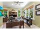 Well-lit home office featuring wood floors, custom cabinetry, and large windows with natural light at 10007 Hillspring Dr, Huntersville, NC 28078