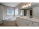 Bright bathroom featuring double vanity, and a soaking tub with decorative window at 104 Nottingham Dr, Maiden, NC 28650