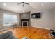 Cozy living room with wood floors, fireplace, mounted television, and large window at 104 Nottingham Dr, Maiden, NC 28650