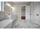 Bright bathroom with marble floors, double vanity, soaking tub, and an open doorway at 106 Kelly Marie Ct, Kings Mountain, NC 28086