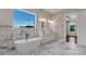 Bright bathroom features marble floors and walls, soaking tub, glass shower, double sink vanity and natural light at 106 Kelly Marie Ct, Kings Mountain, NC 28086