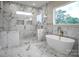 Bright bathroom features soaking tub, glass shower, marble floors and walls, and gold hardware at 106 Kelly Marie Ct, Kings Mountain, NC 28086