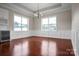 Living room featuring dark hardwood floors, modern light fixture, and bright windows overlooking the front yard at 106 Kelly Marie Ct, Kings Mountain, NC 28086