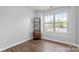 Well-lit bedroom with large window providing ample natural light and wood-look flooring at 11023 Kinston Ridge Pl, Charlotte, NC 28273